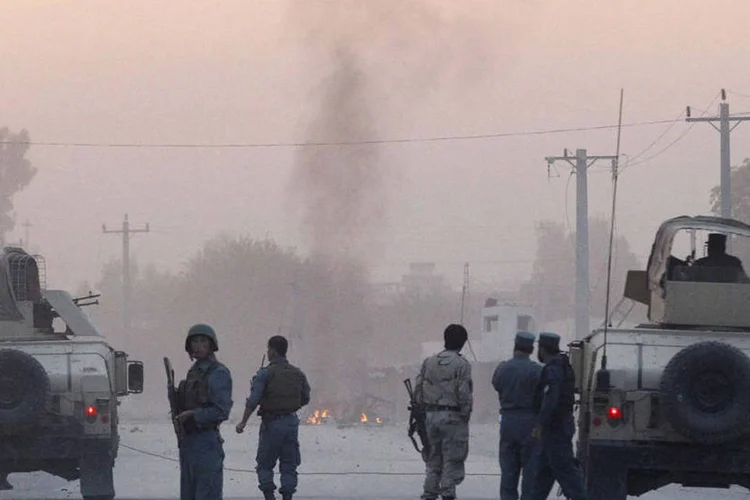 
	Policiais afeg&atilde;os ao lado do local onde ocorreu ataque com carro bomba: o an&uacute;ncio do grupo foi feito muito tempo depois de o governo ter informado sobre a recaptura de Kunduz
 (Reuters/Parwiz)