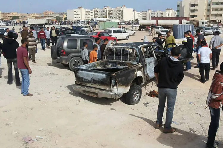 Populares observam o local da explosão de um carro-bomba na cidade de Tobruk, no leste da Líbia, perto da fronteira com o Egito (Reuters)