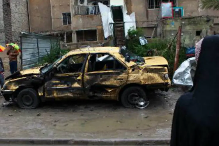 Moradores de Bagdá se aproximam de local onde um carro-bomba explodiu: outro ataque ocorreu durante reunião de cúpula árabe na capital iraquiana em 2012 (Ahman Al-Rubaye/AFP)