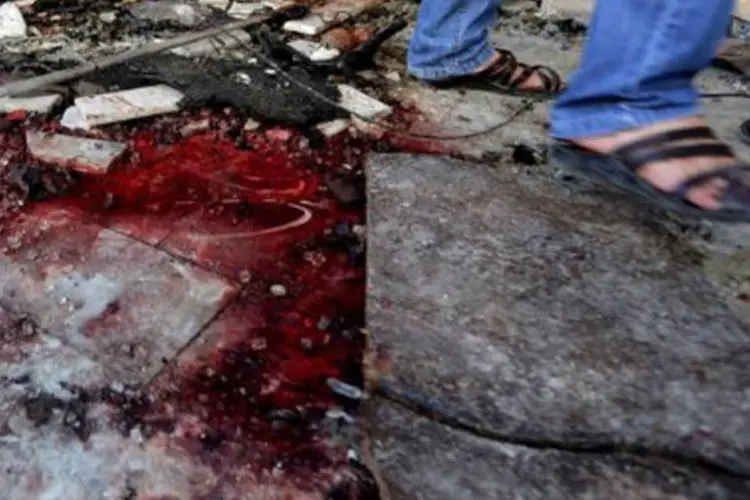 
	Homem passa por sangue ap&oacute;s a explos&atilde;o de um carro-bomba em Jaramana, sub&uacute;rbio de Damasco: 12 pessoas morreram e 48 ficaram feridas nessa explos&atilde;o
 (Joseph Eid/AFP)