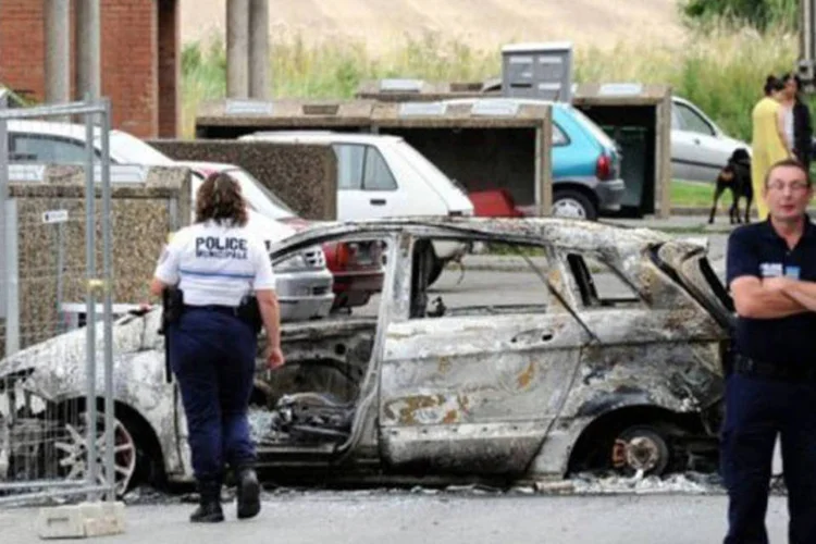 
	Carro &eacute; encontrado incendiado ap&oacute;s confrontos entre jovens e policiais em Amiens, norte da Fran&ccedil;a: pr&eacute;dios p&uacute;blicos tamb&eacute;m foram destru&iacute;dos
 (Philippe Huguen/AFP)
