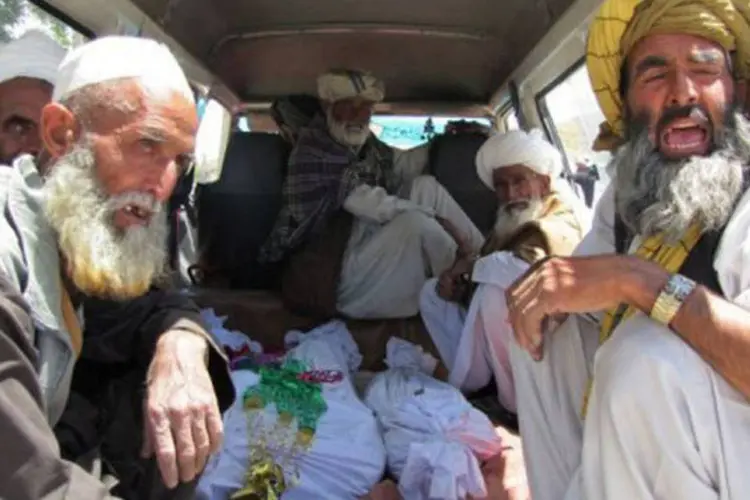 Afegãos em carro carregam corpos de crianças mortas em ataque em junho: segundo a ONU, número de vítimas civis caiu 15% no país (AFP)
