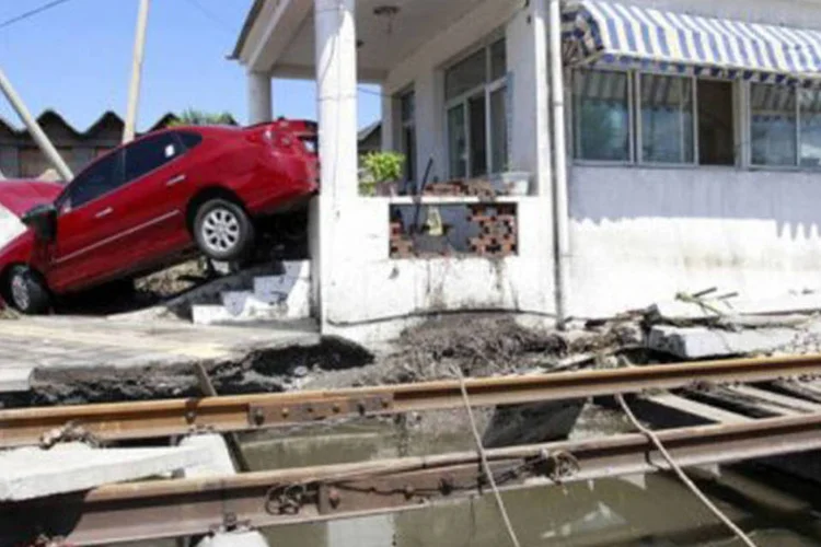 Desastre na China: a correnteza jogou um carro no quintal de uma casa de Pequim (Str/AFP)