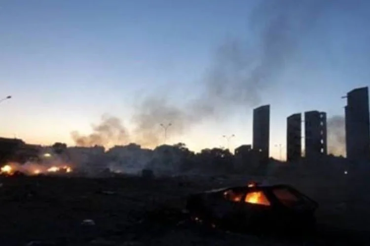 Carcaça de um carro queima em Benghazi: Líbia vive crise política (Patrick Baz/AFP)