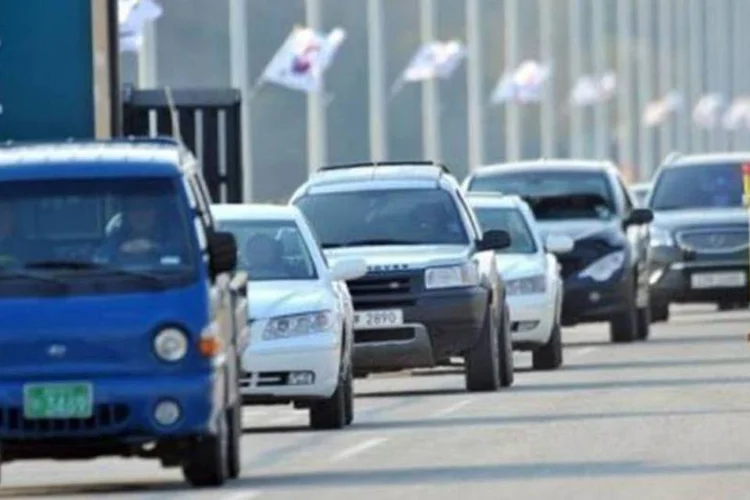 Veículos sul-coreanos passam por barricada na estrada que vai até o complexo de Kaesong (©afp.com / Jung Yeon-Je)
