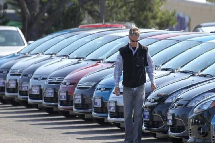 
	Homem passa na frente de carros em p&aacute;tio: Segundo os dados, a produ&ccedil;&atilde;o tamb&eacute;m caiu ao passar de 318.701 unidades em outubro para 301.679 (-5,3%) em novembro
 (Getty Images)