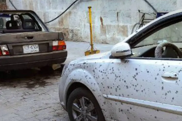 
	Carros com marcas de tiros perto da mesquita: disparos de obuses no centro da capital pelos rebeldes s&atilde;o cada vez mais comuns
 (AFP)