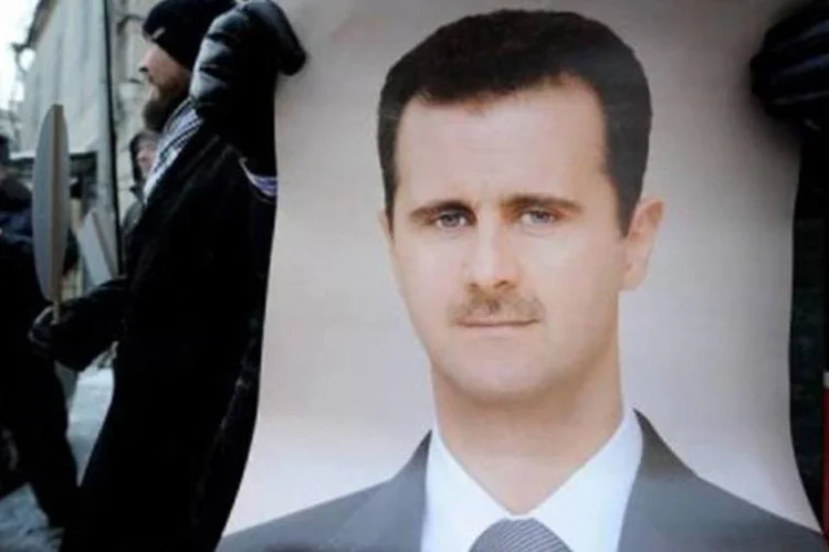 Homem segura cartaz em apoio a Assad em frente à embaixada síria em Moscou: Rússia tem poder de veto na ONU (Natalia Kolesnikova/AFP)