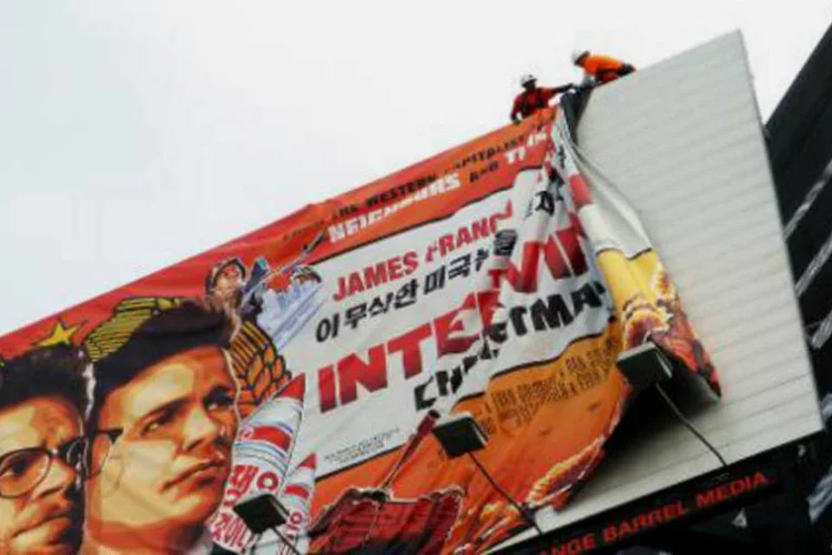 Funcionários retiram cartaz do filme "A Entrevista" de área em Hollywood, Califórnia (Veronique Dupont/AFP)