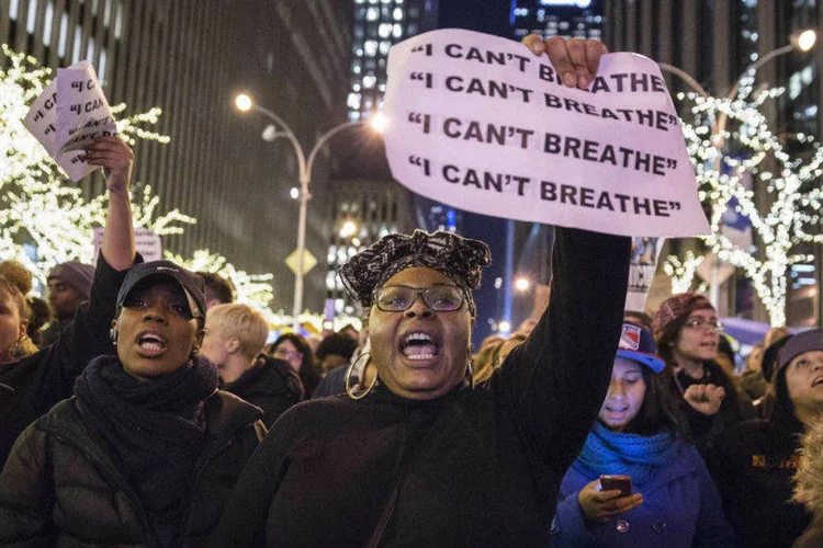 Mulher segura cartaz reproduzindo a fala de Garner, em marcha no complexo Rockefeller Center, NY (Elizabeth Shafiroff/Reuters)