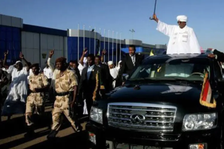 O presidente do Sudão, Omar al-Bashir, é saudado por simpatizantes no aeroporto de Cartum em 14 de novembro
 (Ashraf Shazly/AFP)