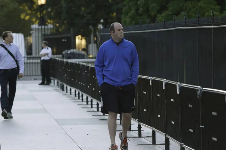 Pedestre caminha ao lado da nova cerca de segurança montada na Casa Branca, em Washington (Gary Cameron/Reuters)