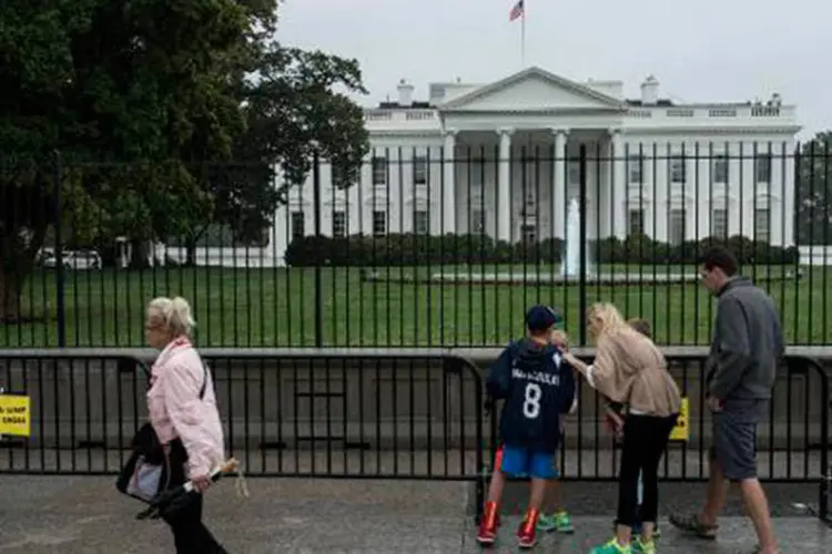 Pessoas passam pela Casa Branca (Brendan Smialowski/AFP)