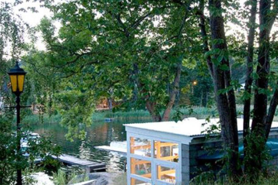 Arquiteta usa janelas velhas como paredes em casa no lago