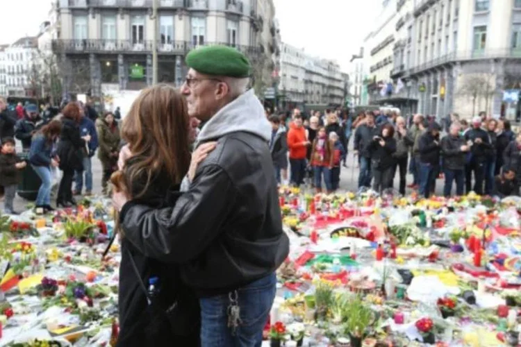 Casal se abraça em meio a homenagem às vítimas dos atentados da Bélgica, em Bruxelas (Nicolas Maeterlinck/AFP)