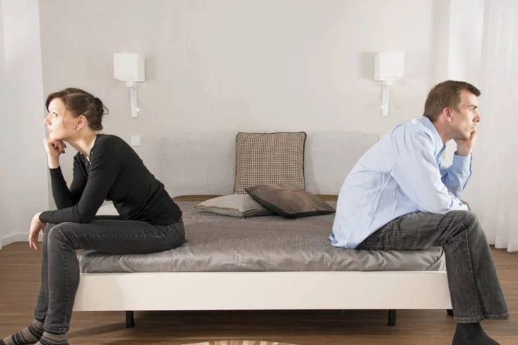 
	Casal sentado em lados opostos da cama: Tudo que for adquirido durante o casamento &eacute; repartido na comunh&atilde;o parcial


 (ThinkStock/Andreas_Krone)