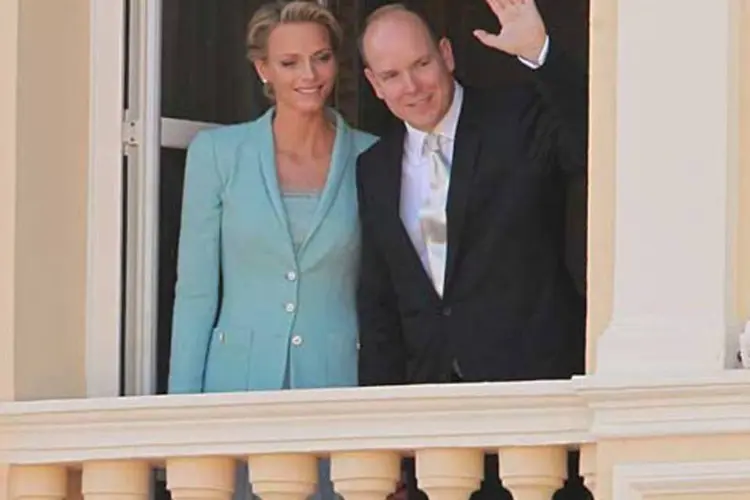 O príncipe Albert II e sua esposa Charlene Wittstock acenam numa sacada em Mônaco (Sean Gallup / Getty Images)