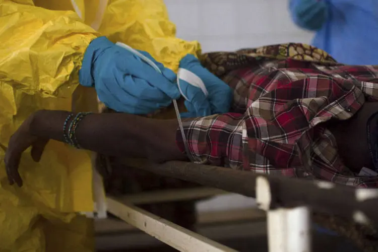 Médicos extraem amostra de sangue de um paciente suspeito de estar infectado com Ebola, em Serra Leoa (Tommy Trenchard/Reuters)
