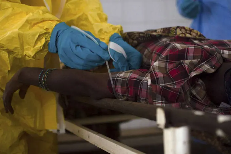 
	M&eacute;dicos extraem amostra de sangue de um paciente suspeito de estar infectado com ebola, em Serra Leoa
 (Tommy Trenchard/Reuters)