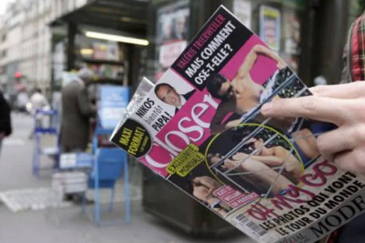 
	Homem l&ecirc; a revista com as fotos de Catherine, a duquesa de Cambridge: a&nbsp;publica&ccedil;&atilde;o das imagens criou um grande rebuli&ccedil;o no&nbsp;Reino Unido
 (Kenzo Tribouillard/AFP)