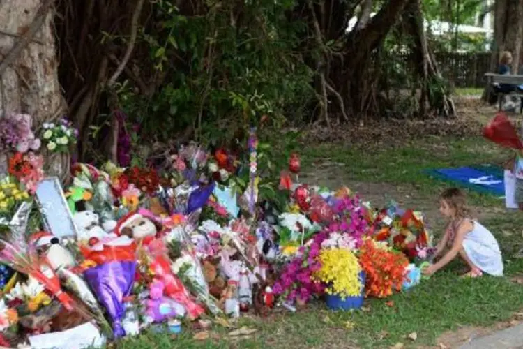 Crianças depositam flores diante da casa na qual oito menores de idade foram encontrados mortos na cidade de Cairns, norte da Austrália (AFP)