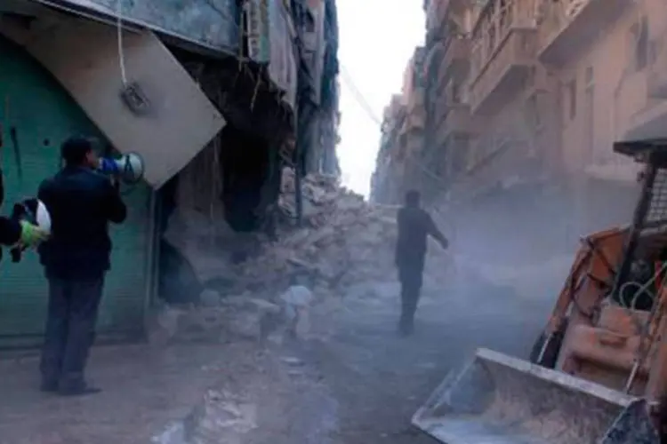 Escavadeira chega para remover os escombros após um ataque aéreo na cidade síria de Aleppo, na Síria (Fouad Hallak/AFP)