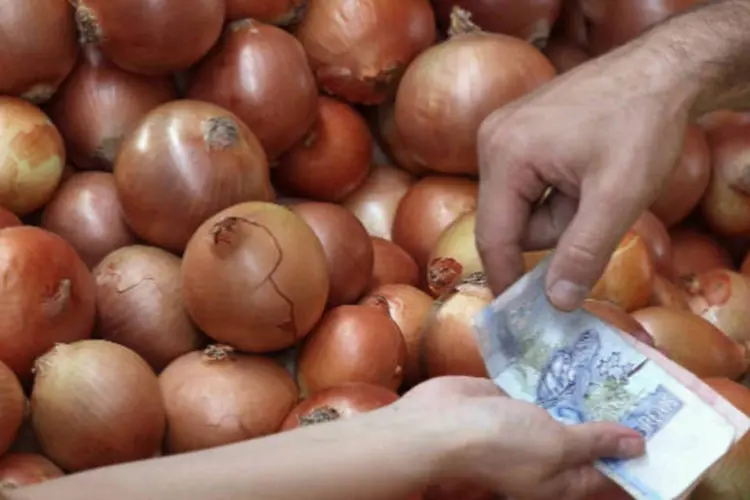 
	Comerciante entrega troco para consumidora que compra cebolas em feira de S&atilde;o Paulo
 (REUTERS/Paulo Whitaker)