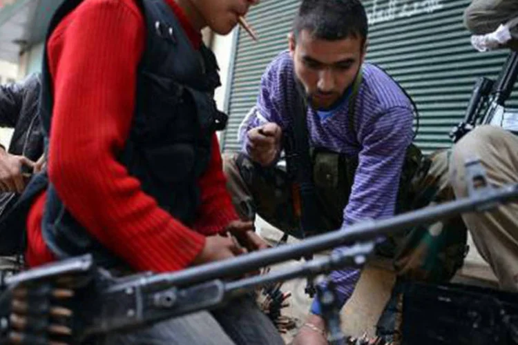Rebeldes sírios carregam as armas no bairro de maioria curda Sheikh Maqsud, na cidade de Alepo, em 4 de abril de 2013 (Dimitar Dilkoff/AFP)