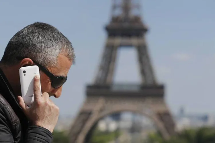 Homem falando ao celular próximo da Torre Eiffel, em Paris (Christian Hartmann/Reuters)