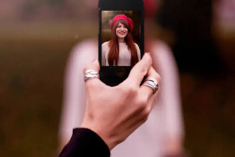 Mulher é fotografada com celular: com o aplicativo Asap54 para iPhone os usuários tiram uma foto de um item e descrevem o que é para ajudar o aplicativo a identificá-lo (Getty Images)