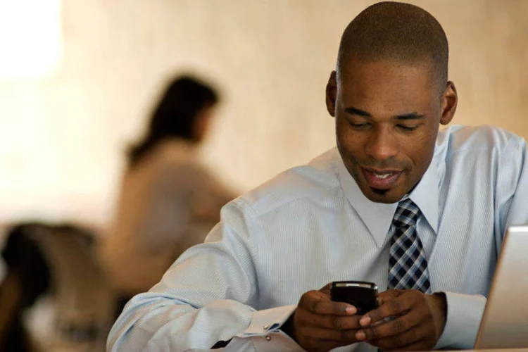 Homem olha celular: por exemplo, pessoas que não deixam que celulares fiquem com pouca bateria tendem a evitar que seus saldos devedores baixem (Ingram Publishing/Thinkstock)