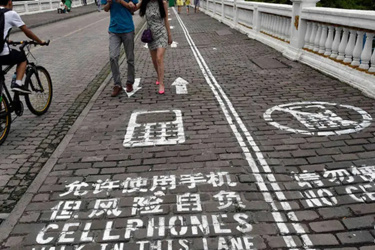 Casal anda na primeira calçada para usar celulares na China, instalada no município de Chongqing (REUTERS/China Daily)