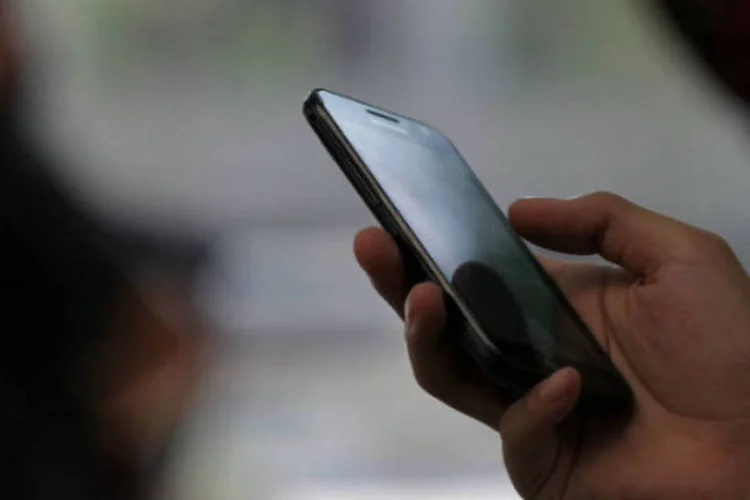 
	Pessoa segura smartphone: as vendas de celulares cresceram ontem 55% ante um ano antes, respondendo por cerca de 17% do total de vendas
 (Woohae Cho/Bloomberg)