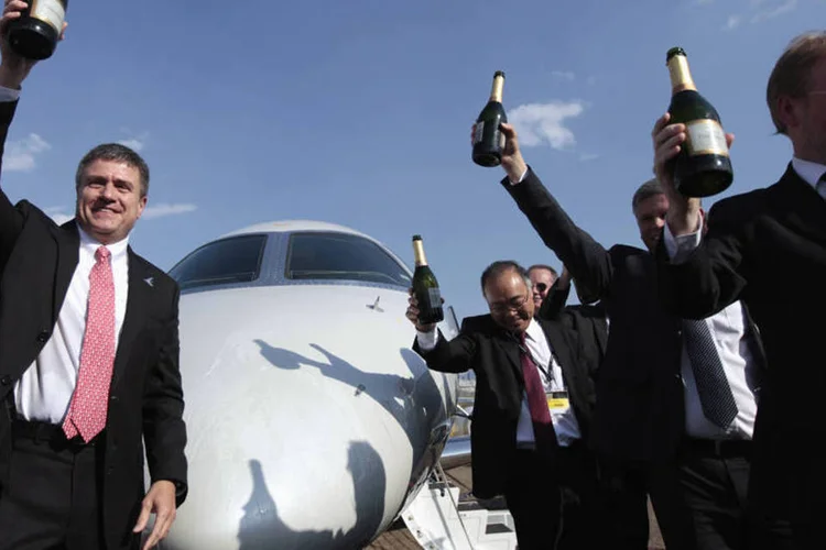 Marco Túlio Pellegrini celebra com funcionário o lançamento do Legacy 500, em Congonhas (Paulo Whitaker/Reuters)