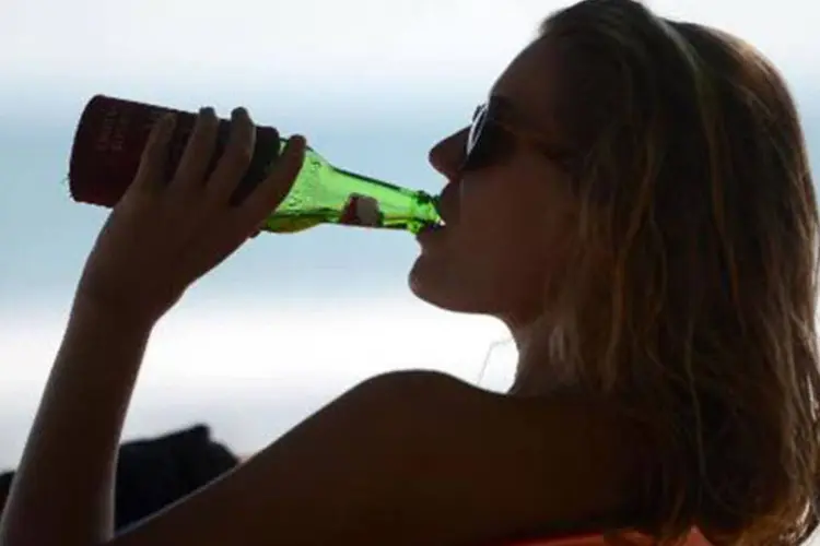 
	Turista estrangeira bebe cerveja na praia de Kuta na ilha de Bali: hot&eacute;is, restaurantes e bares n&atilde;o ser&atilde;o afetados pela proibi&ccedil;&atilde;o
 (Sonny Tumbelaka/AFP)