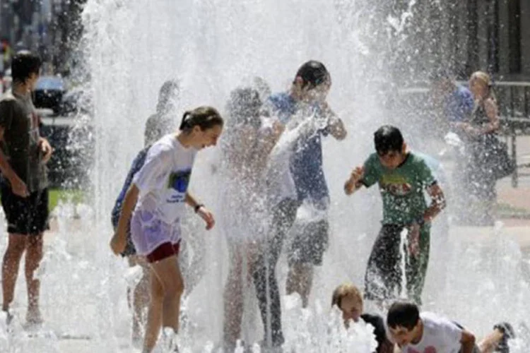 Jovens franceses se refrescam do forte calor em um chafariz da cidade de Lyon (Philippe Desmazes/AFP)