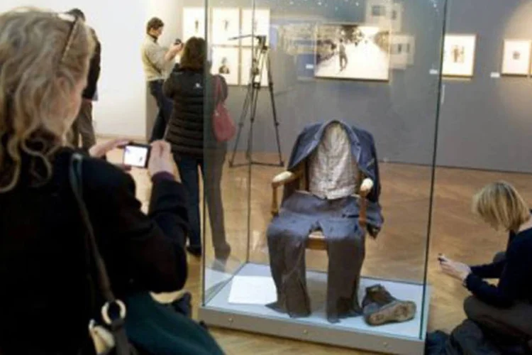 
	Franceses observam objetos de Charlie Chaplin uma exposi&ccedil;&atilde;o em homenagem ao ator e diretor brit&acirc;nico em Evian, em 2011: o ator decidiu usar o figurinho h&aacute; quase um s&eacute;culo
 (Philippe Merle/AFP)