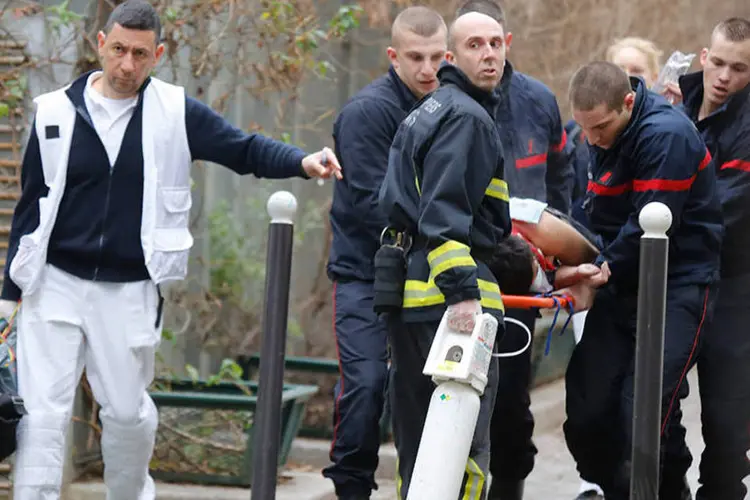 Bombeiros carregam vítima após atentado a jornal francês: testemunha afirma ter escutado "pelo menos dez tiros" antes de ver um policial ferido na rua (REUTERS/Jacky Naegelen)