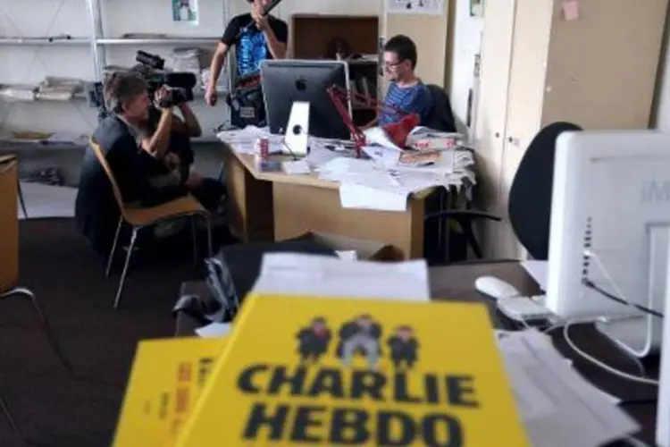 Diretor da revista Charlie Hebdo, Charb (d), na sede da publicação em Paris (Thomas Samson/AFP)