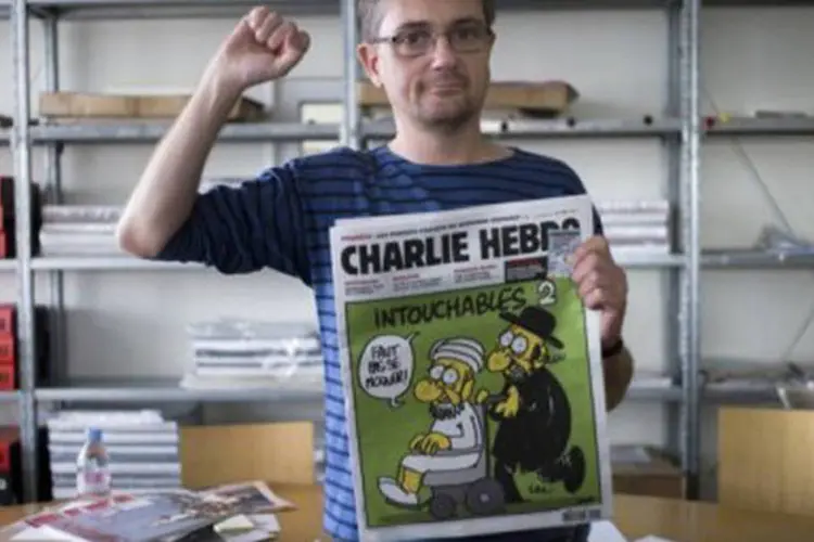 O editor da revista Charlie Hebdo's, conhecido apenas como Charb, exibe a edição com caricatura de Maomé
 (Fred Dufour/AFP)