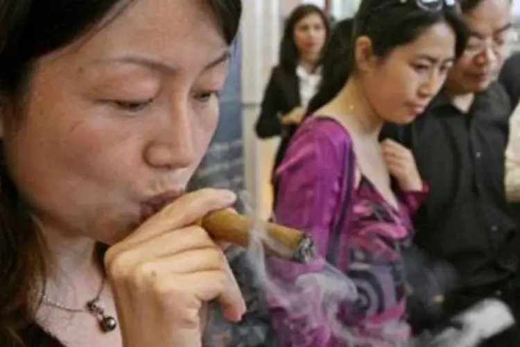 Chinesa fuma um charuto em Xangai: vendas crescem em novos mercados (Mark Ralston/AFP)