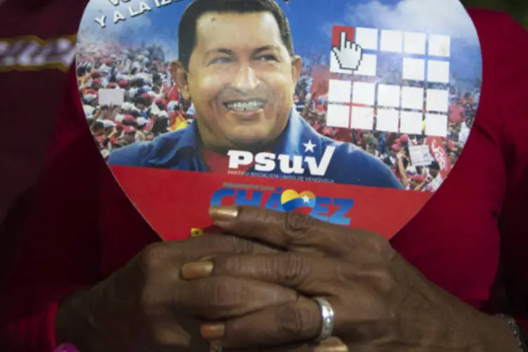 Uma apoiadora do presidente venezuelano, Hugo Chávez, segura foto dele em cerimônia em Caracas em 31 de dezembro de 2012 (REUTERS/Carlos Garcia Rawlins)
