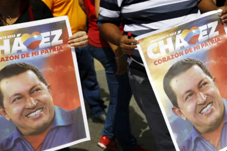 
	Venezuelanos carregam cartazes de apoio ao presidente: a posse para mais um mandato presidencial de Ch&aacute;vez est&aacute; marcada para o dia 10
 (REUTERS/Carlos Garcia Rawlins)
