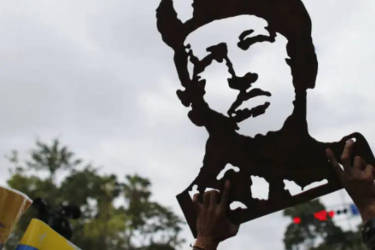 Apoiador do presidente venezuelano, Hugo Chávez, segura imagem esculpida em madeira durante manifestação diante do Palácio Miraflores, em Caracas (Jorge Silva/Reuters)