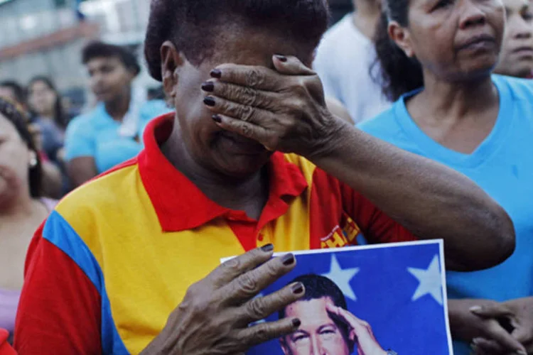 
	Apoiadores do presidente venezuelano, Hugo Ch&aacute;vez, reagem ao an&uacute;ncio de sua morte:&nbsp;apesar da dor demonstrada no rosto dos chavistas, muitos afirmam que continuar&atilde;o o legado de Ch&aacute;vez, que governou desde 1999.
 (Carlos Garcia Rawlins/Reuters)