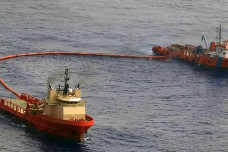 Barcos com barreiras de contenção controlando a mancha de óleo no campo de Frade provocada pela Chevron (Divulgação/Chevron Brasil Petróleo)
