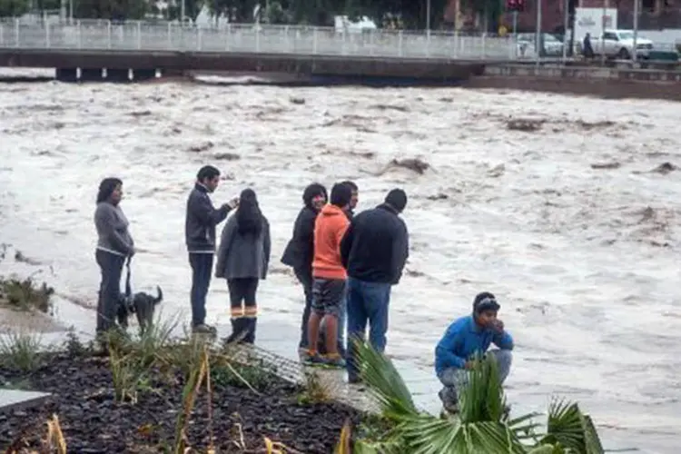 
	Moradores observam a cheia do rio Copiap&oacute; em 25 de mar&ccedil;o: as chuvas deixaram mais de 2.300 desabrigados em Atacama
 (Alex Fuentes/AFP)