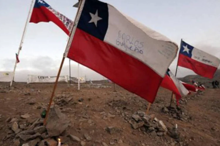 Velas acesas junto com bandeiras do Chile na mina San José (Rodrigo Arangua/AFP)