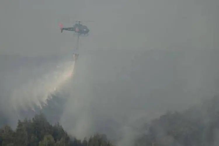 
	Um helic&oacute;ptero dos bombeiros tenta controlar o fogo em inc&ecirc;ndio florestal em Valpara&iacute;so, Chile
 (VLADIMIR RODAS/AFP)