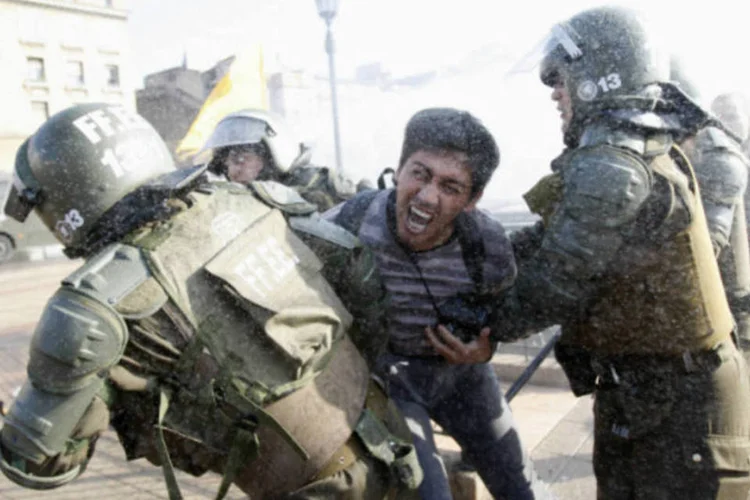 Manifestante é detido em meio a confronto com a polícia durante uma greve nacional em Santiago, no Chile (Carlos Vera/Reuters)